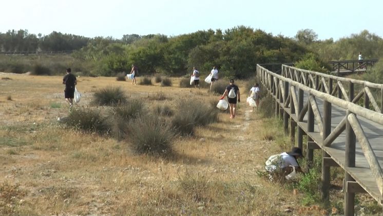 Voluntarios retiran basura del litoral de Chipiona para concienciar sobre la importancia de no tirar residuos en esa zona natural
